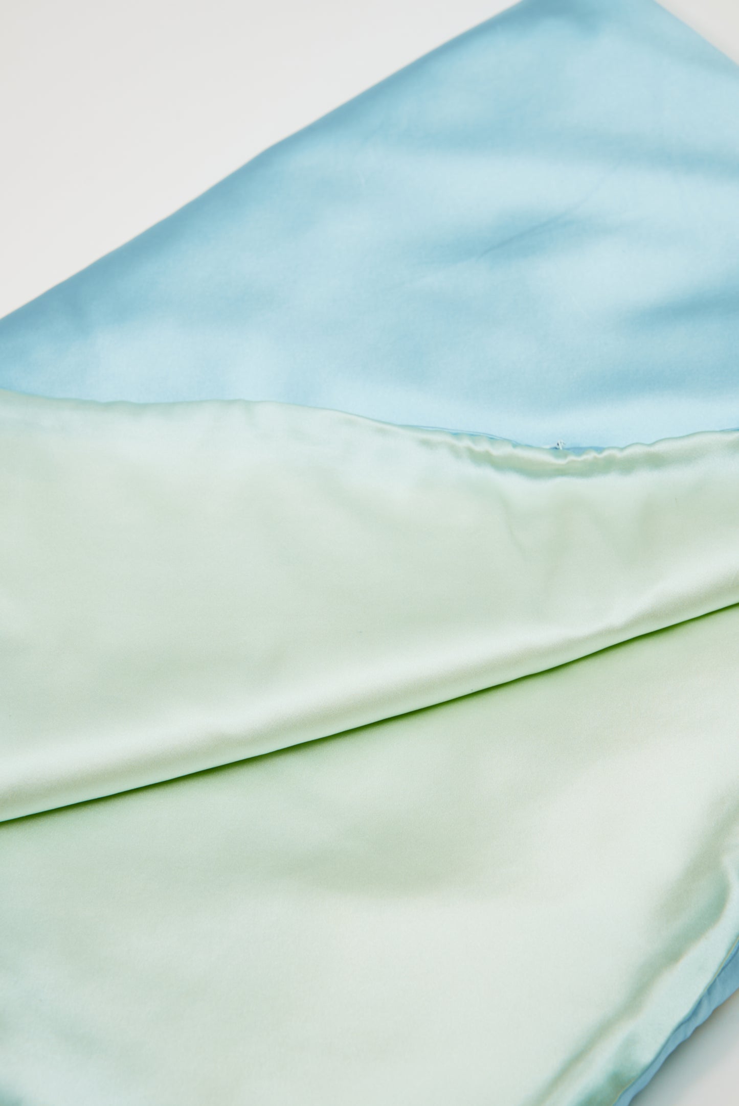 Close-up of premium 6A silk texture on a baby blue blanket, ultra-soft, breathable and eco-friendly.