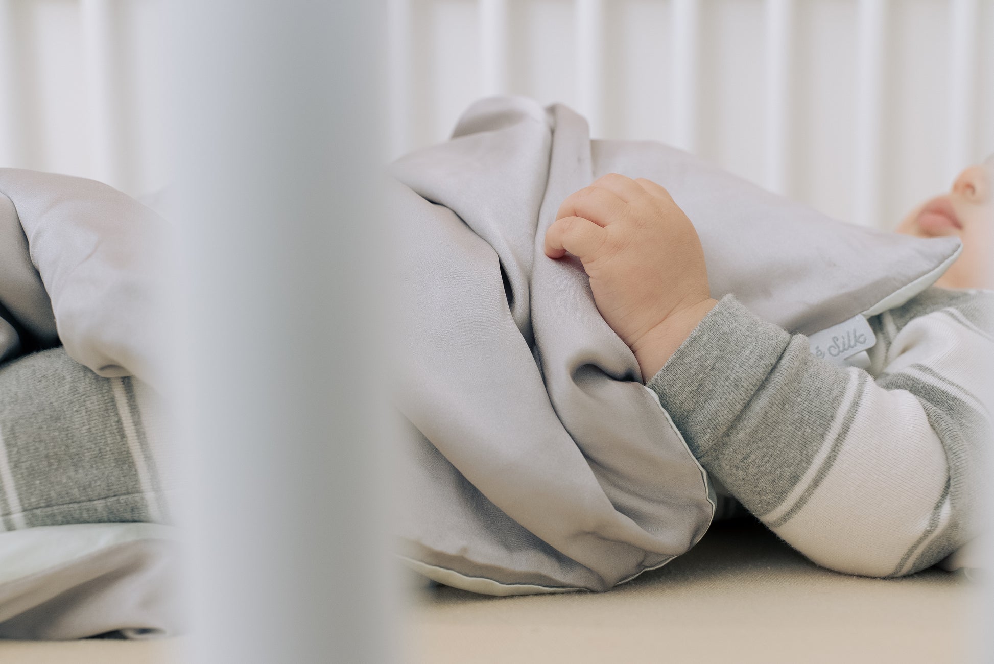 Premium 6A silk baby blanket in baby pink styled on a cozy nursery bed, smooth, breathable, vegan and sustainable.