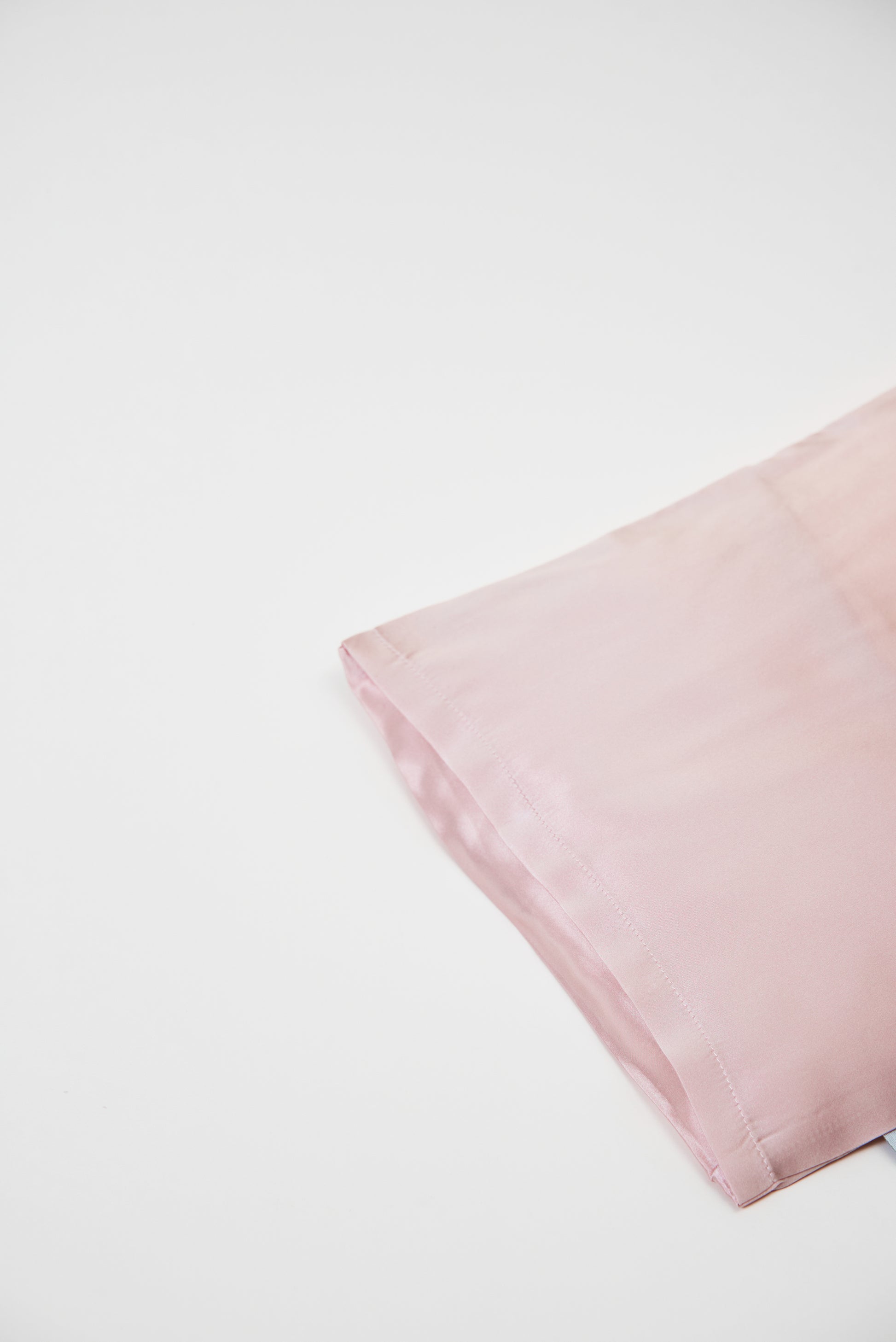 Close-up of premium 6A silk texture on a baby pink pillow, ultra-soft, breathable and eco-friendly.
