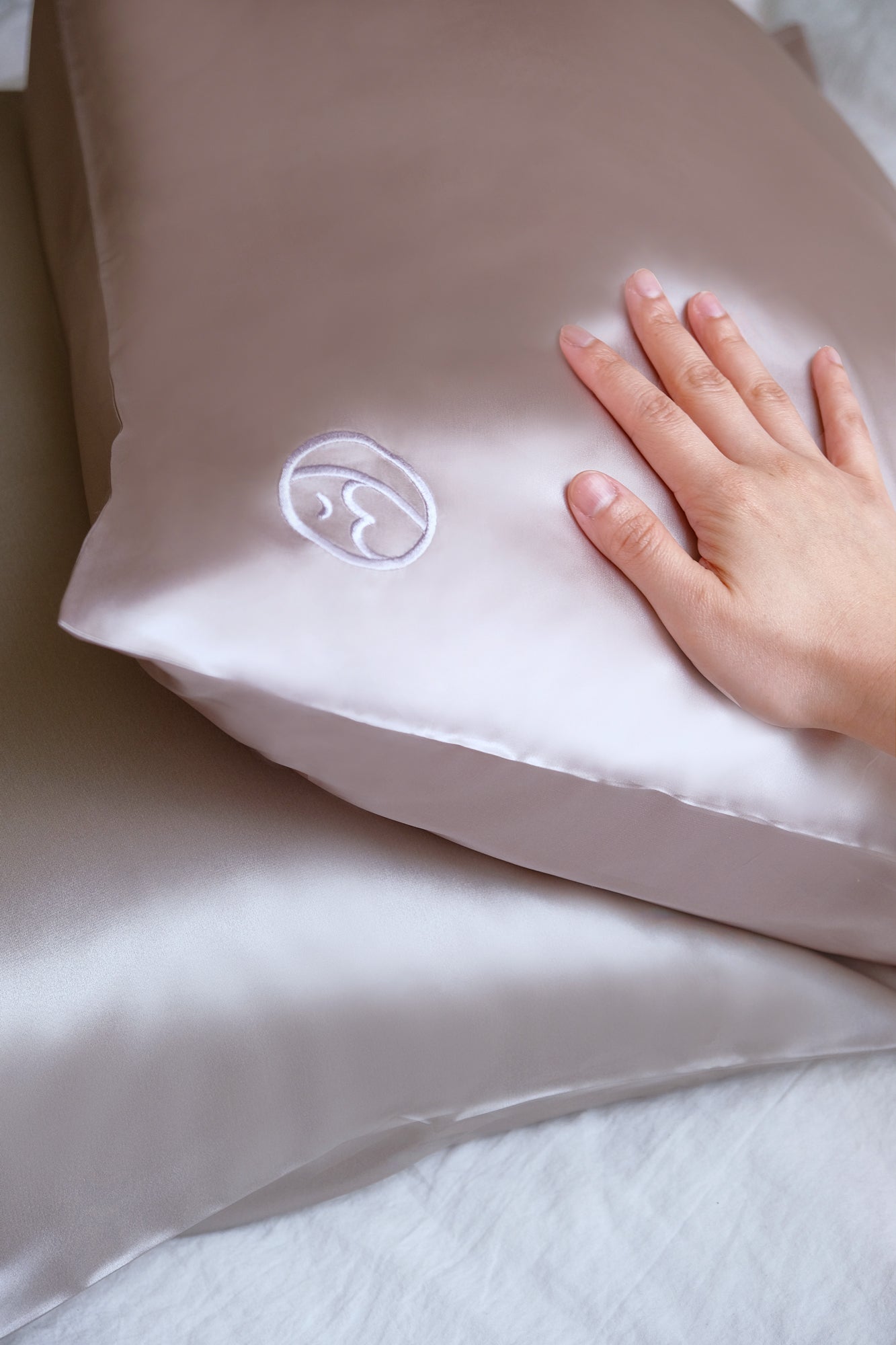 Close-up of premium 6A silk texture on a silver pillowcase, ultra-smooth, breathable and eco-friendly.