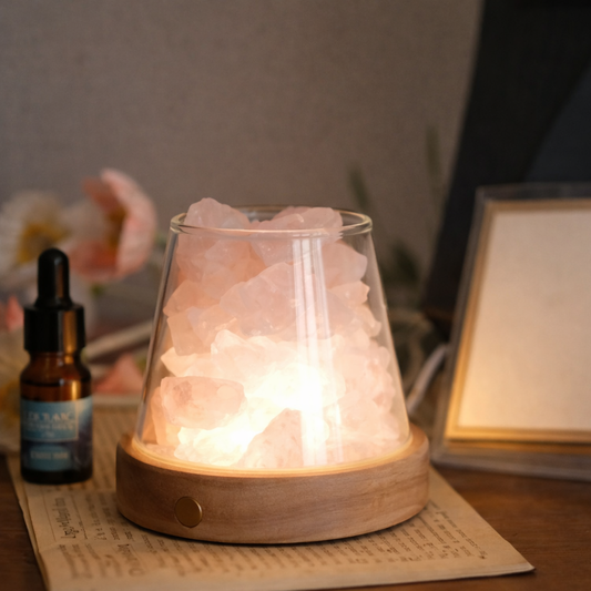 Himalayan salt lamp on a table with a bottle and framed picture in the background