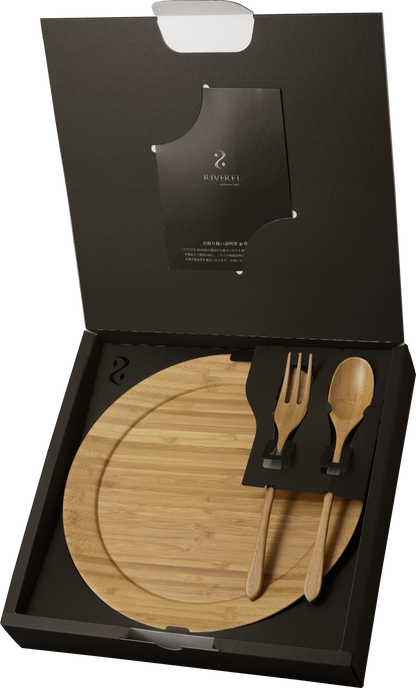 A black gift box opened to reveal a natural bamboo round plate, matching fork, and spoon, perfect for sustainable gift-giving.
