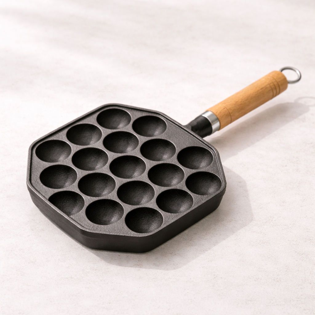 Black cast iron pan with wooden handle on a white background