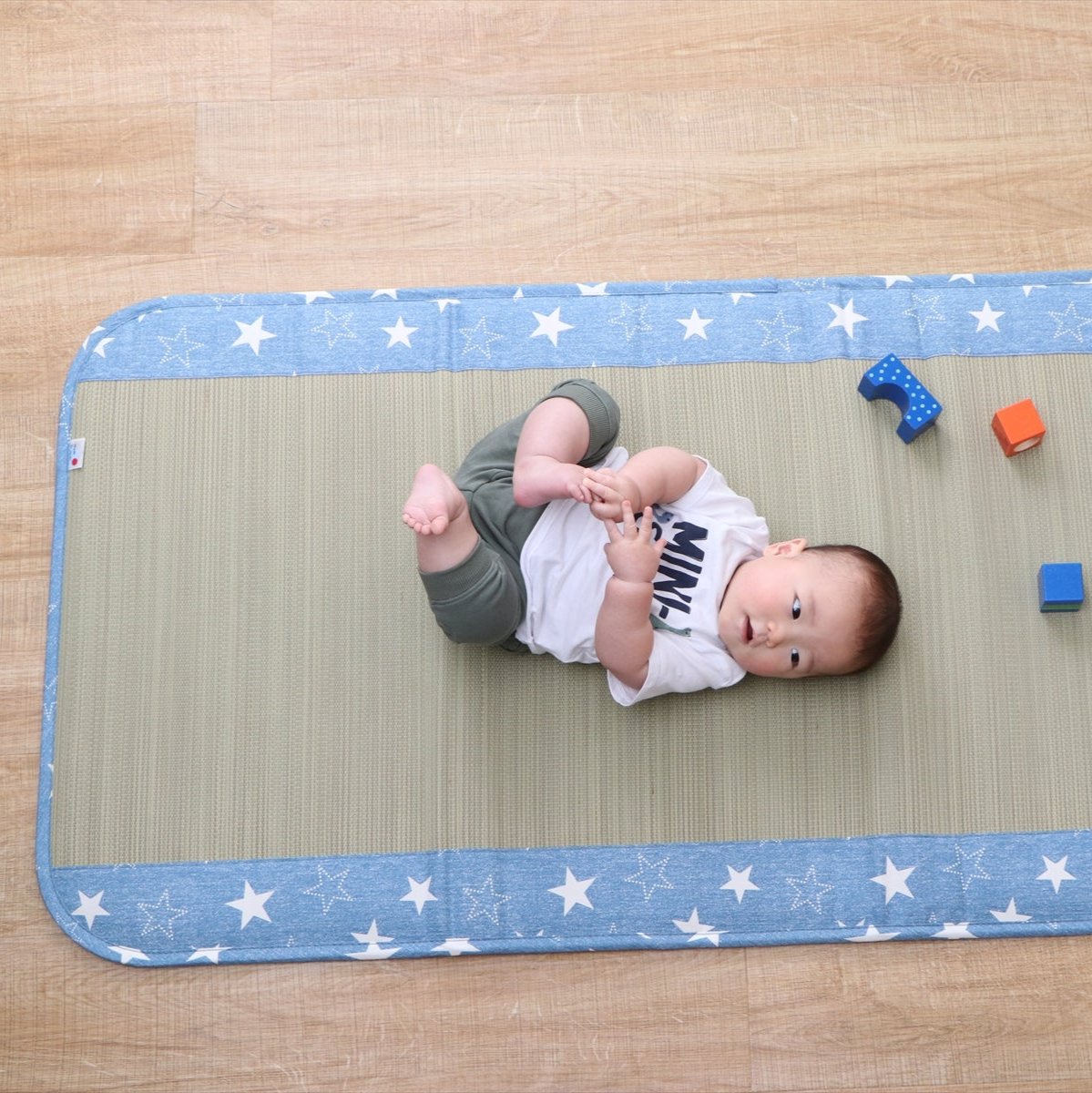 Japanese tatami baby mat made from natural igusa grass, featuring a blue denim border, designed to be vegan, sustainable, and safe for infants.