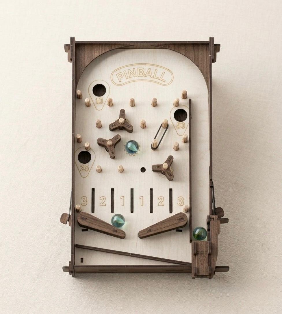 Retro DIY wooden pinball machine with glass marbles displayed on a tabletop