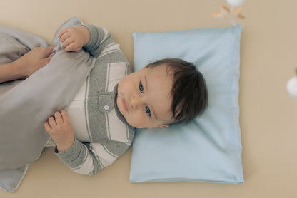 Premium 6A silk baby pillow in baby blue styled on a cozy nursery bed, smooth, breathable, vegan and sustainable.