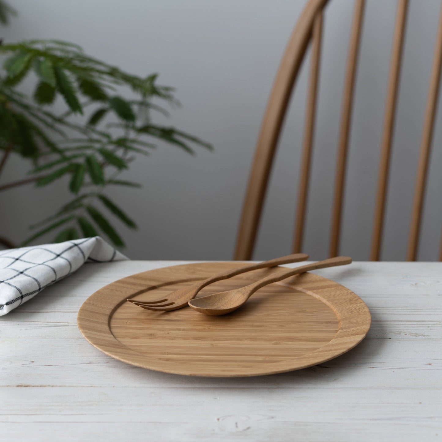 A natural  bamboo dinner plate with a matching spoon and fork set.