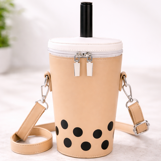 Beige cup-shaped bag with black polka dots and a straw on a light background
