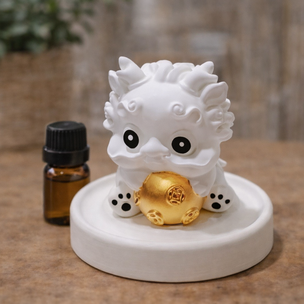 White dragon figurine with a gold egg on a brown surface, next to a small bottle.
