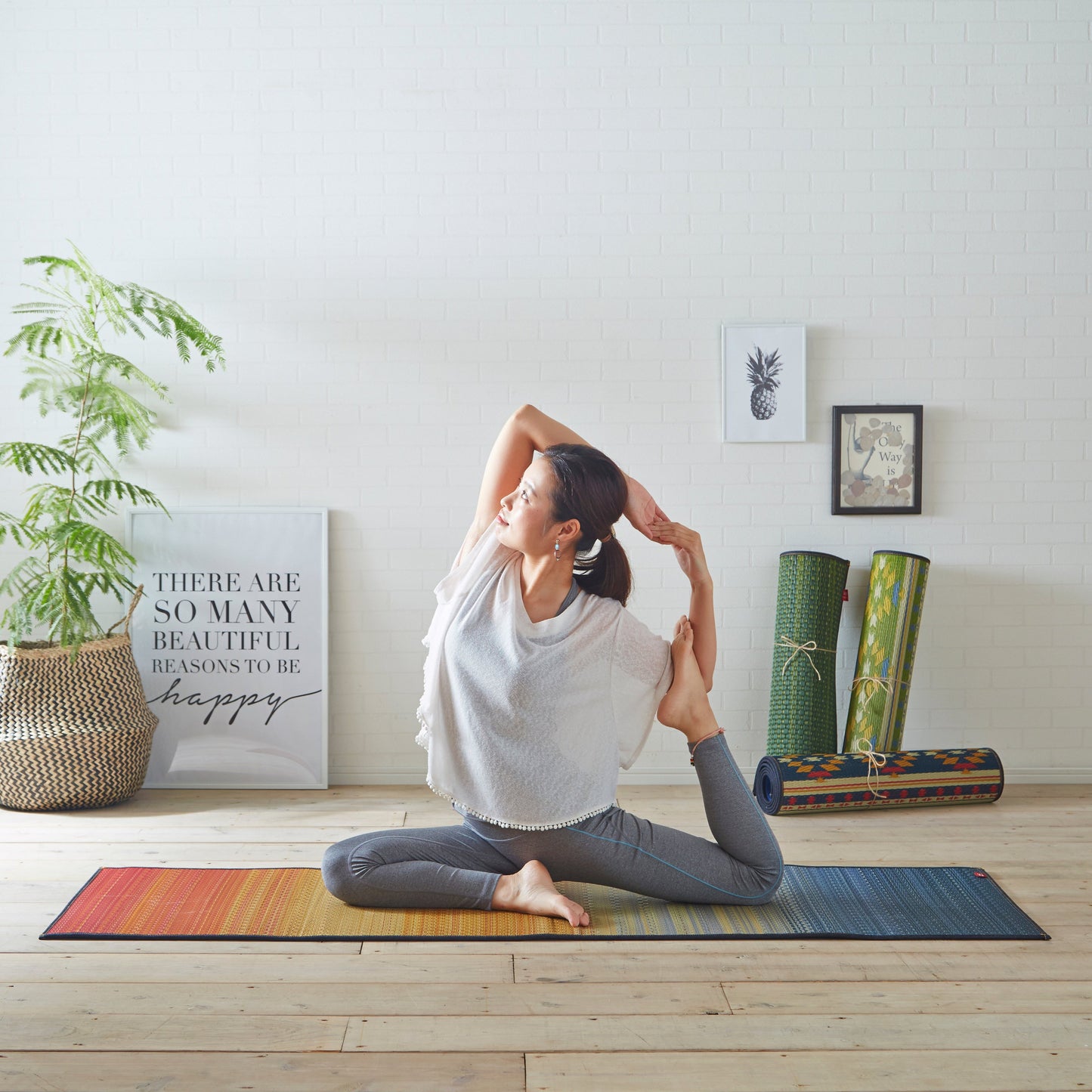 Japanese tatami yoga mat in Joy Red used for yoga and stretching on a wooden floor, natural and sustainable.