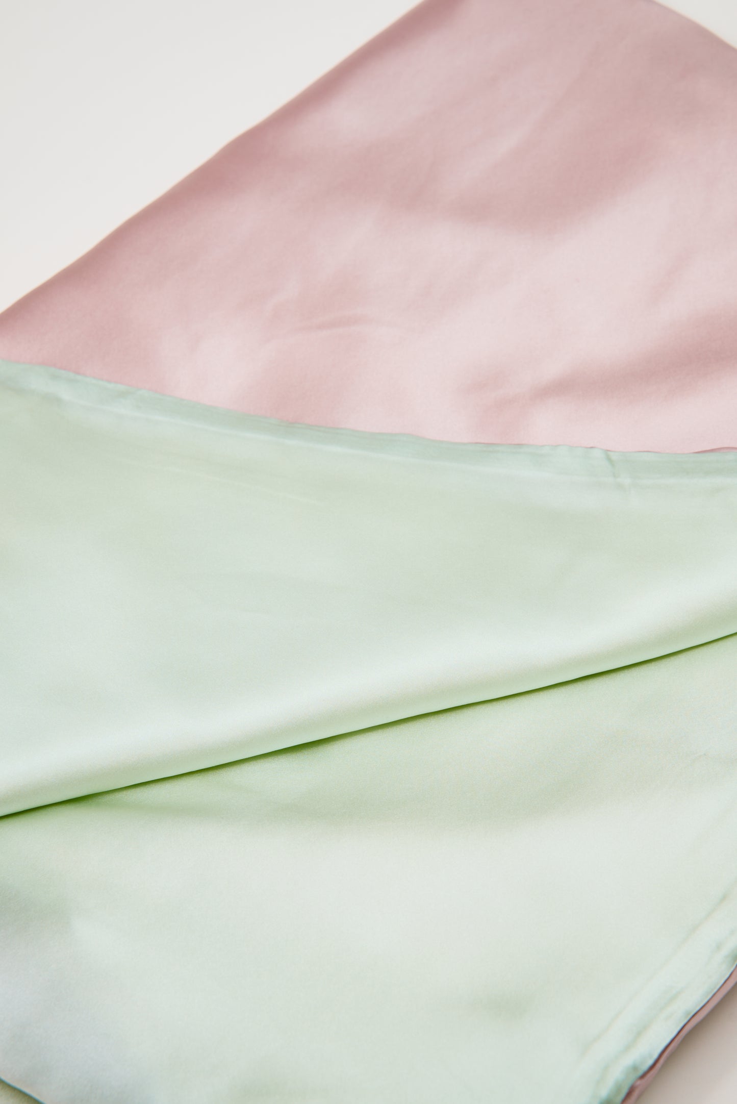 Close-up of premium 6A silk texture on a baby pink blanket, ultra-soft, breathable and eco-friendly.