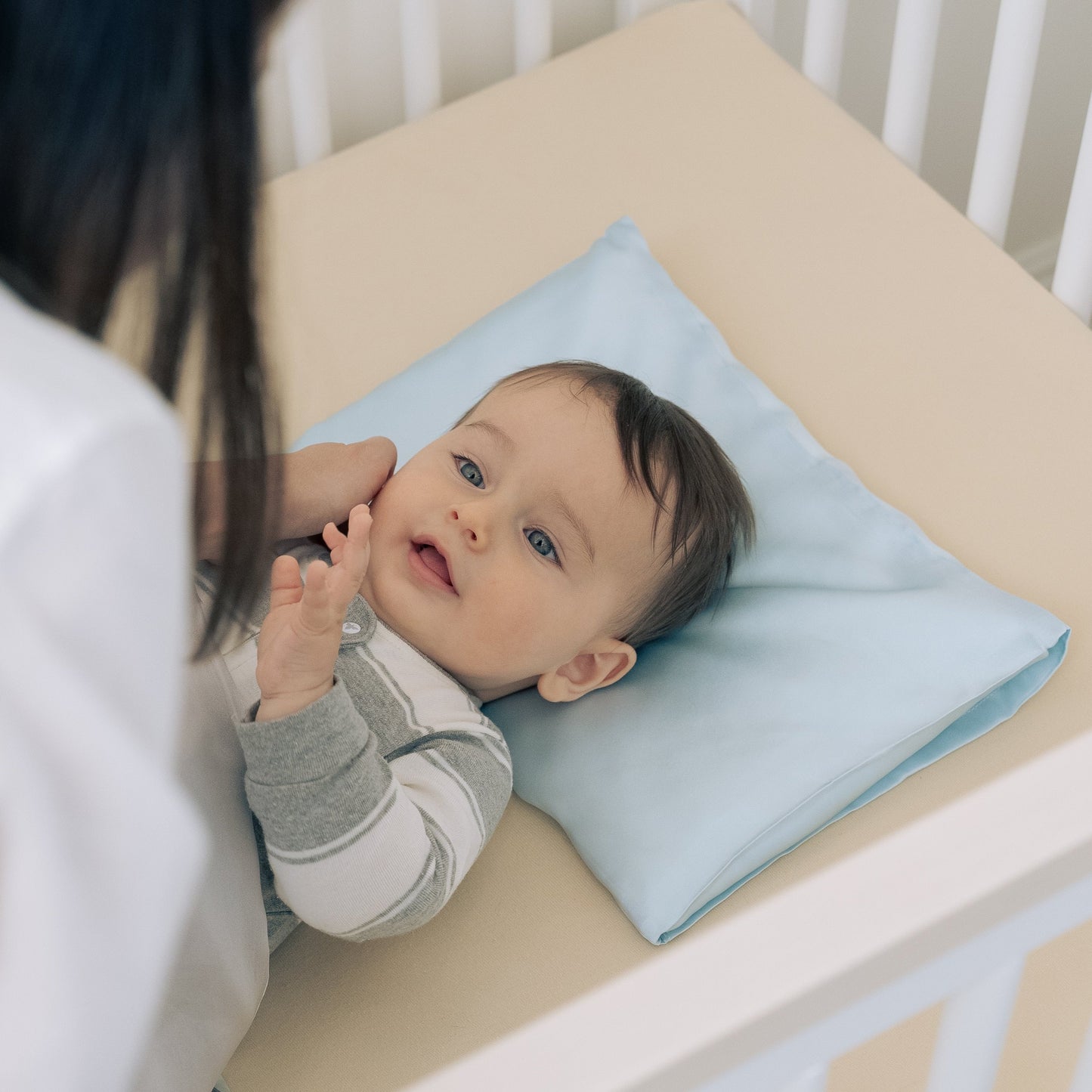 Premium 6A silk baby pillow in baby blue styled on a cozy nursery bed, smooth, breathable, vegan and sustainable.