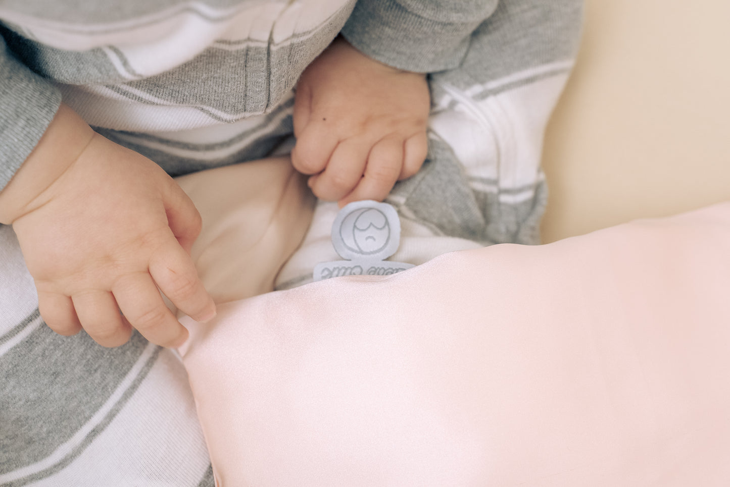 Close-up of premium 6A silk texture on a baby pink pillow, ultra-soft, breathable and eco-friendly.