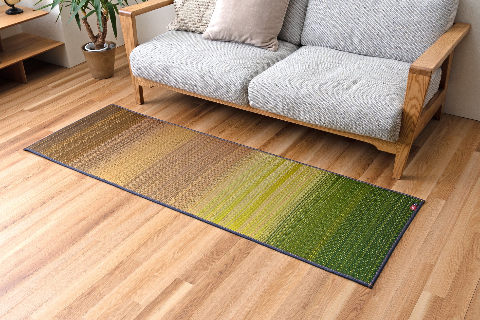 Tatami yoga mat in Joy Green on hardwood floor, crafted from natural igusa grass, vegan and sustainable for mindful yoga practice.